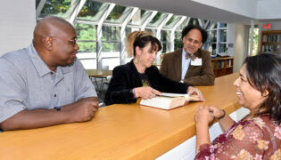 diverse scholars examining a book